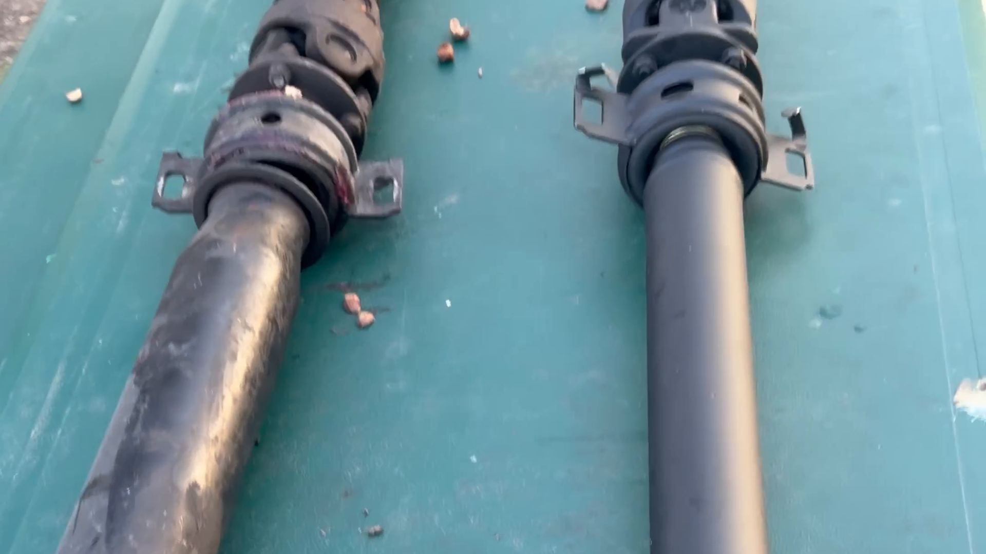 Two driveshafts side by side on a table