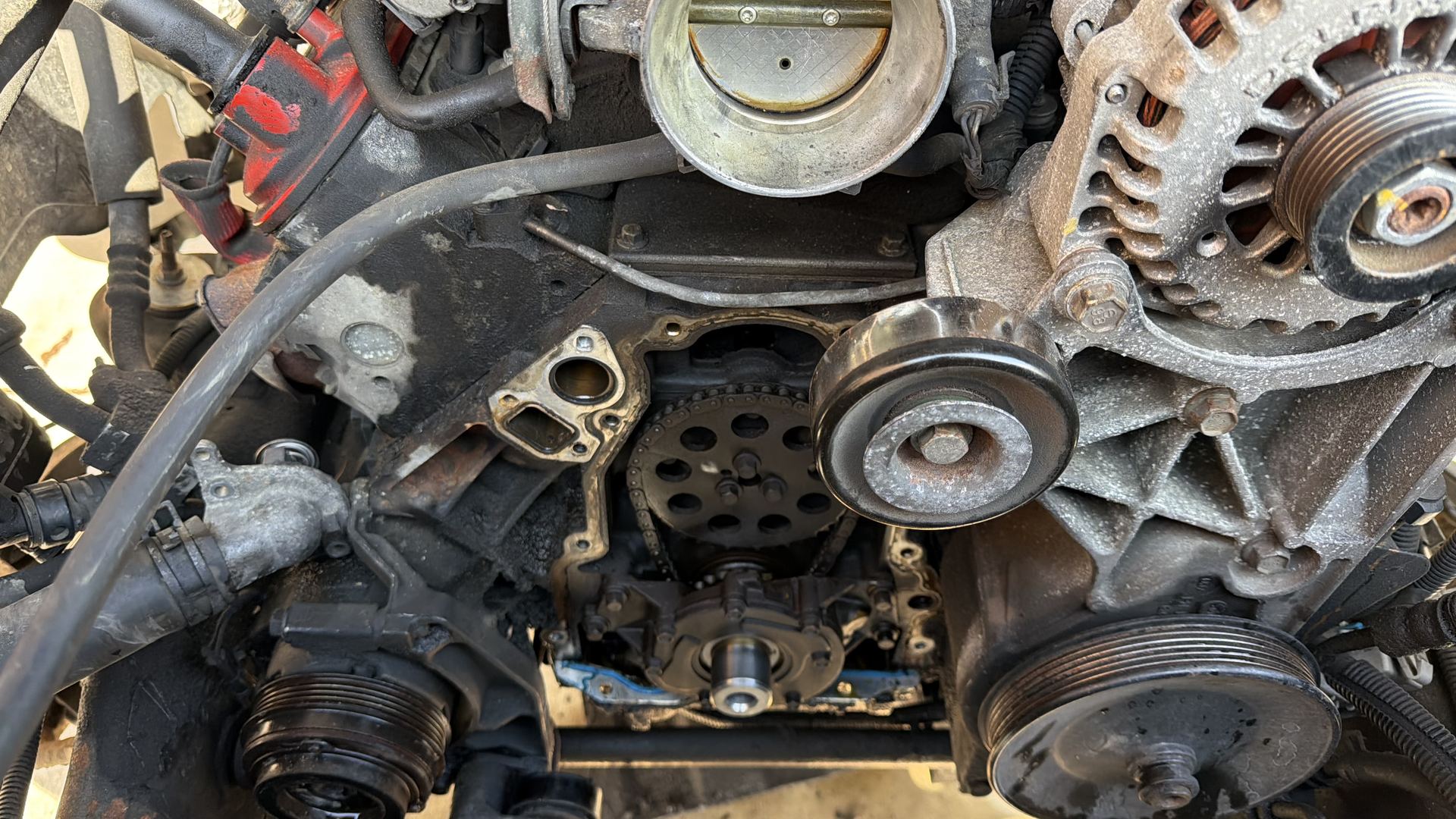 Engine front with the timing chain, alternator and pulleys exposed