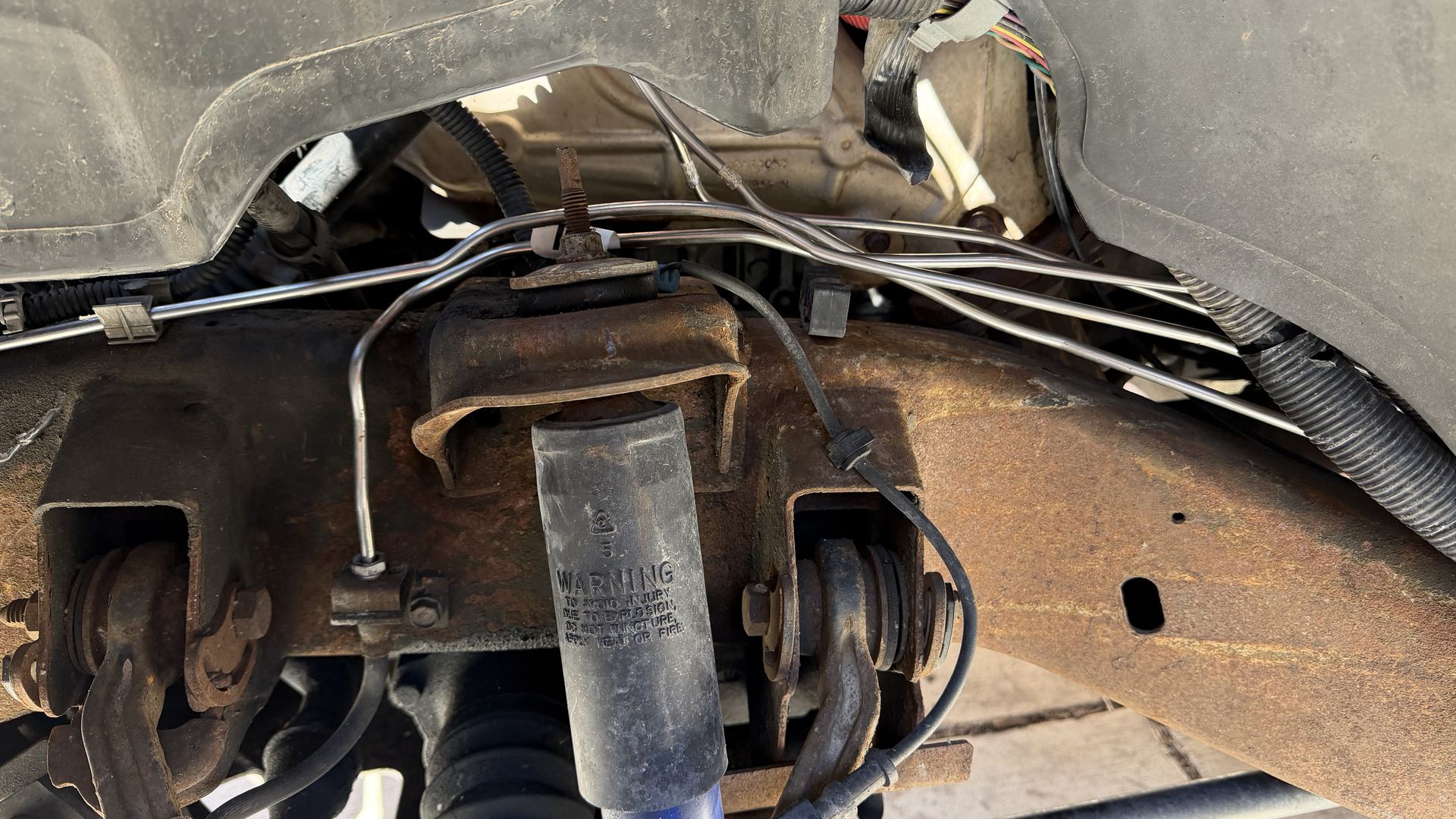 Underside view of a shock absorber, suspension mounts and brake lines