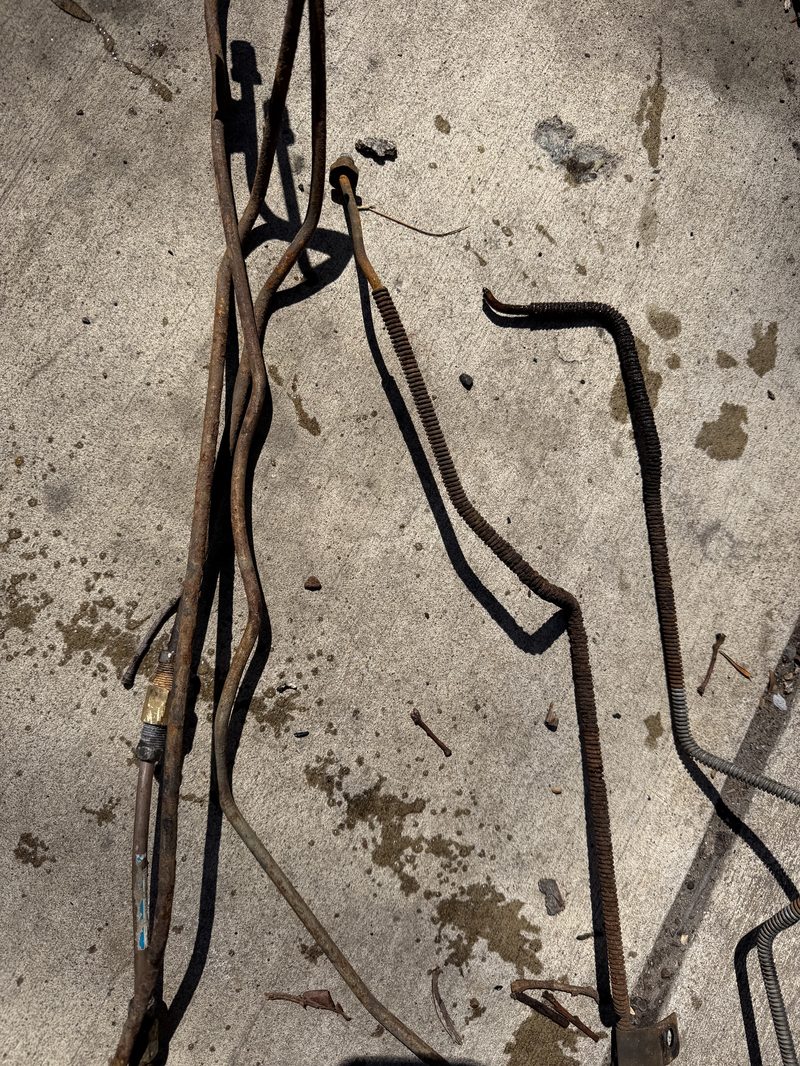 Rusted brake lines removed from a vehicle, close up on the concrete