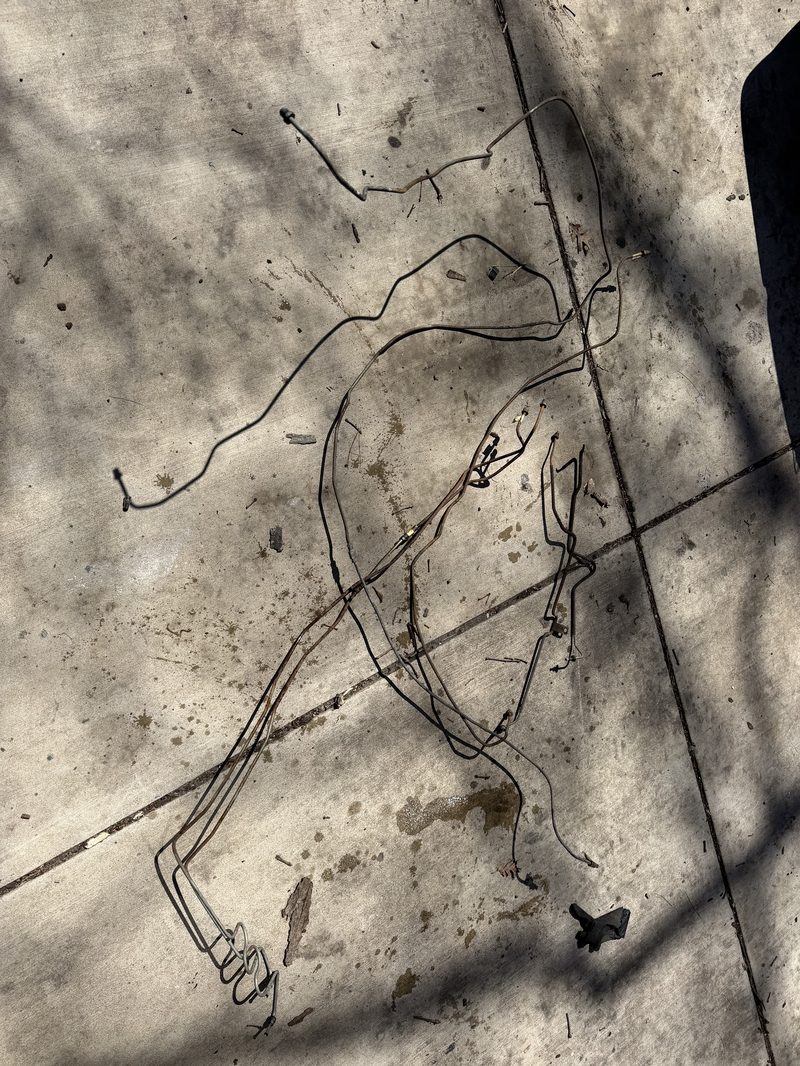 Old brake lines removed and laid out on the concrete