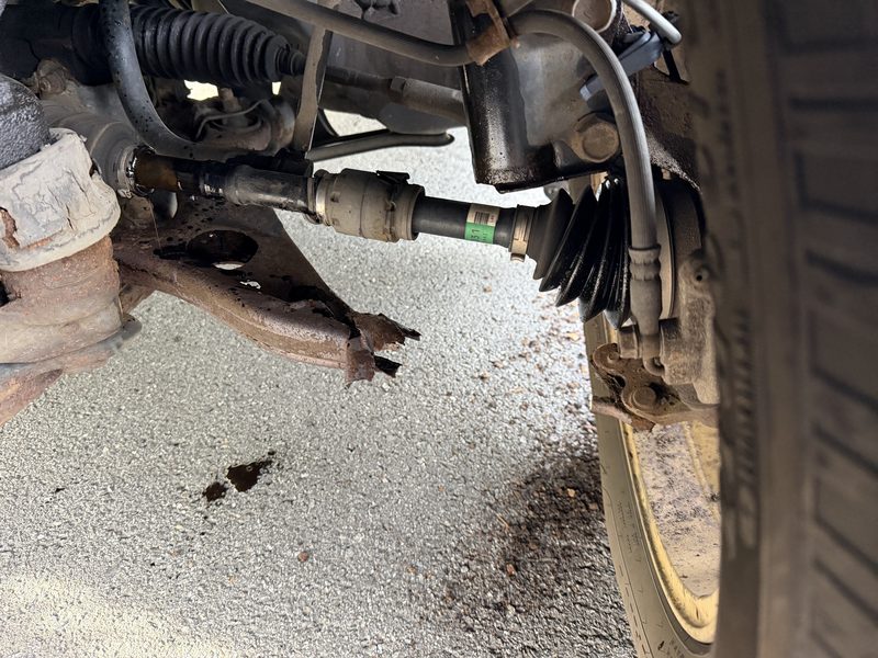 Broken lower control arm visible during undercarriage suspension inspection