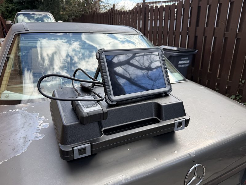 Professional diagnostic scanner and tools set up on vehicle for routine maintenance service