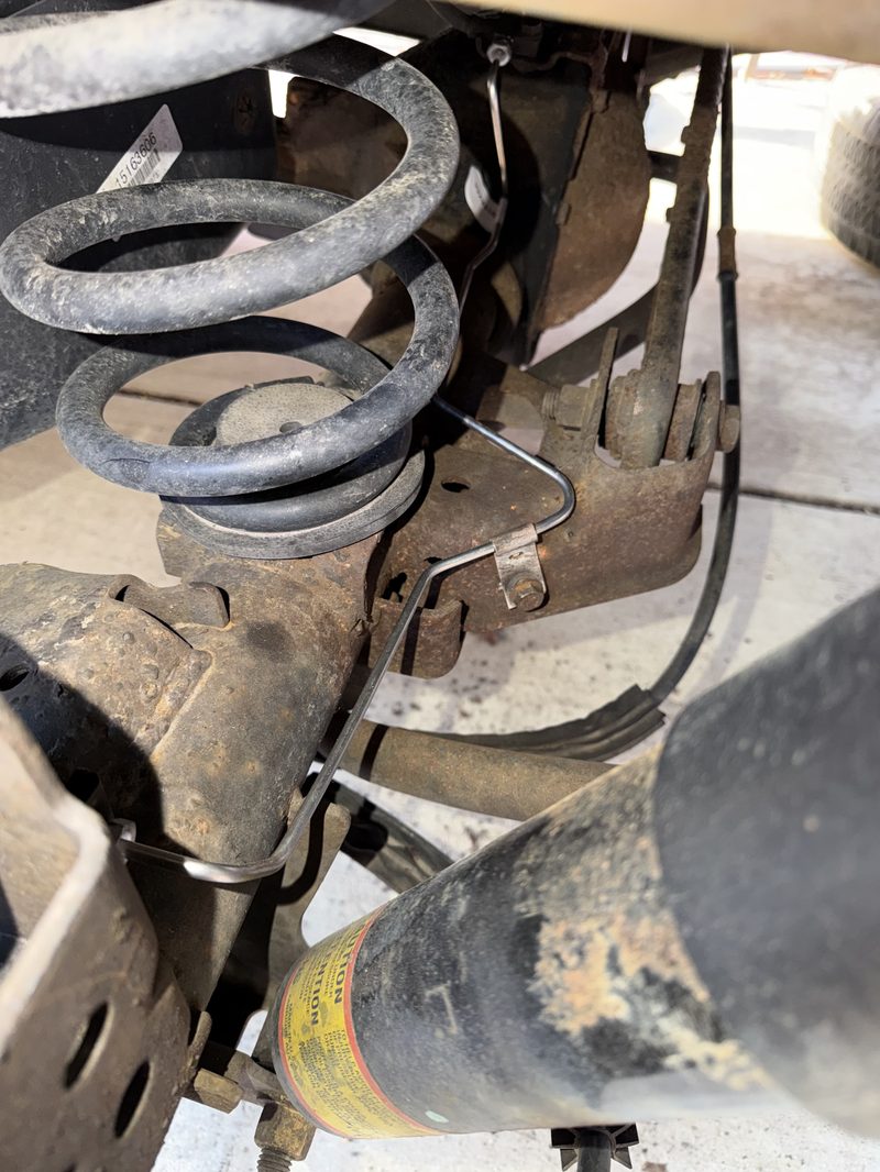 Rear coil spring and shock absorber during suspension service