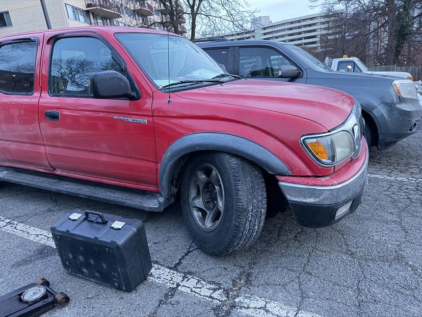Pickup truck in a parking lot with a tool case staged for on-site repair