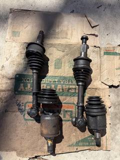 Two CV axles removed from a vehicle, laid on cardboard