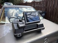 Diagnostic scan tablet and interface case on the hood of a Mercedes-Benz