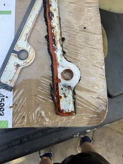 Worn timing cover gasket with old sealant laid out for comparison