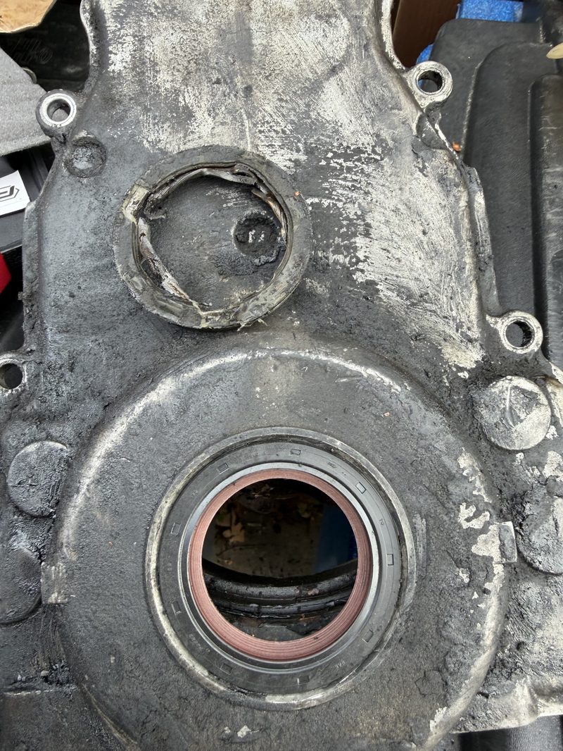 Timing cover with front main seal visible during replacement